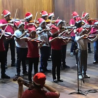 Imagem miniaturizada de crianças realizando uma apresentação musical na Universidade Federal de Goiás